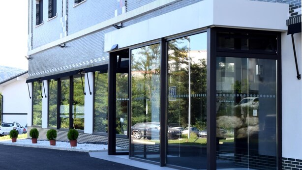 A modern building with large glass windows and a white facade. - Hotel New Bilbao Airport (Derio)