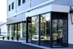 A modern building with large glass windows and a white facade. - Hotel New Bilbao Airport (Derio)