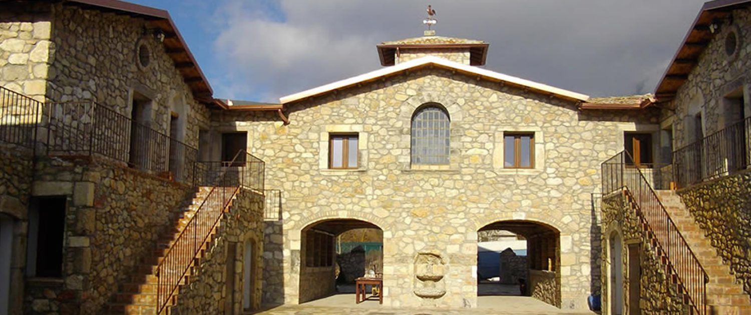 A stone building with a central archway, two side arches, and a staircase on each side.
