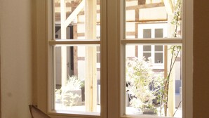 A window with a wooden shelf containing decorative items.