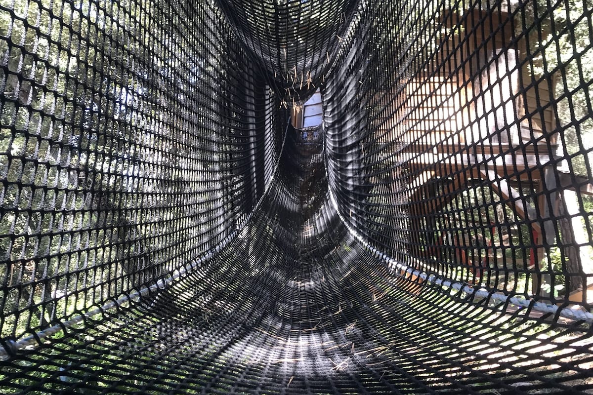 Una estructura en forma de túnel hecha de malla conectada.
