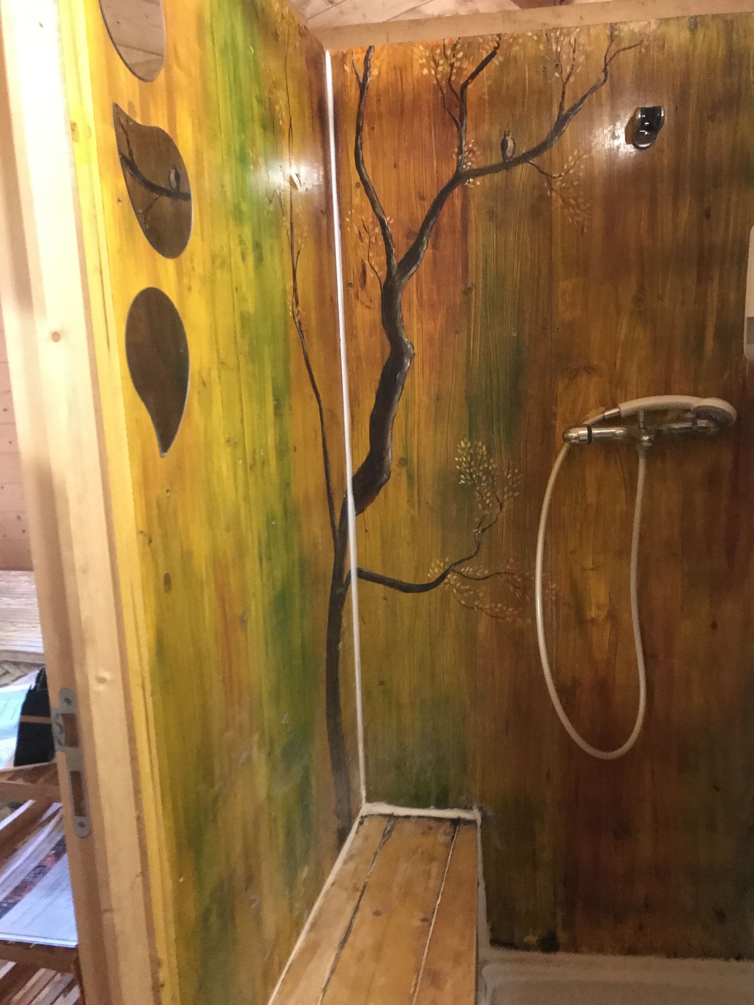 Een houten wand met een ontwerp van een tak en een douchegedeelte.