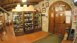 Una bodega con estanterías de vidrio para vino y una puerta de madera.