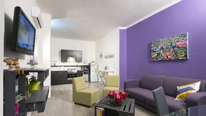 A modern living room with a sofa, chairs, a coffee table, and a TV. - B&B Sleep & Zupp (Naples)