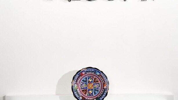 A wall-mounted sign that reads "WELCOME" with decorative swirls above the letters. Below the sign, there is a colorful, circular decorative plate on a white table. - B&B Sleep & Zupp (Naples)