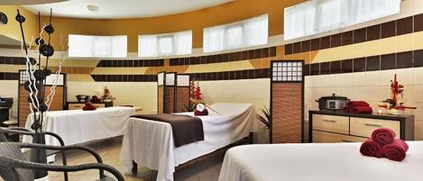 A hotel room with two beds, a small desk, and a chair.
