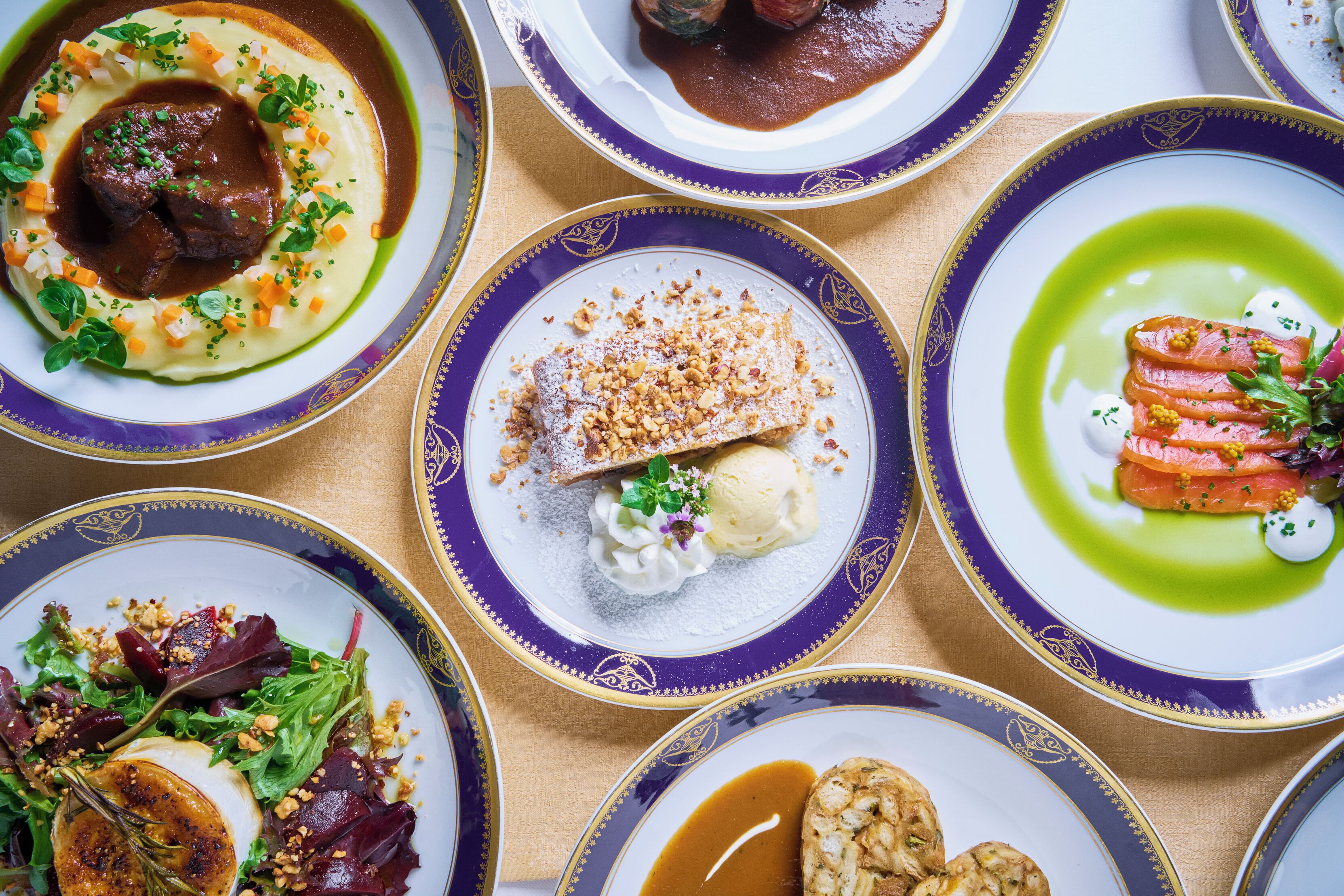 A variety of plated dishes with different garnishes and sauces.