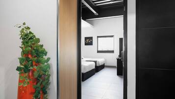A modern hotel room with a bed, bedside tables, and a window.