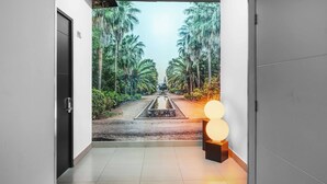 A hallway with a view of a palm-lined pathway and a water feature, leading to a door marked "302". - Homesuites Malecon (Culiacán)
