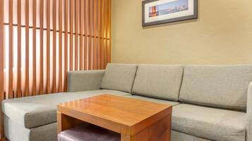 A living room with a beige sofa, a wooden coffee table, and a framed picture on the wall.