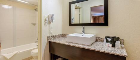 A bathroom with a white sink, a mirror, a towel rack, and a shower.
