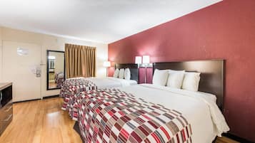 Une chambre d’hôtel avec un grand lit, un bureau et un miroir.