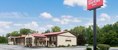Un Red Roof Inn con estacionamiento y varias construcciones.