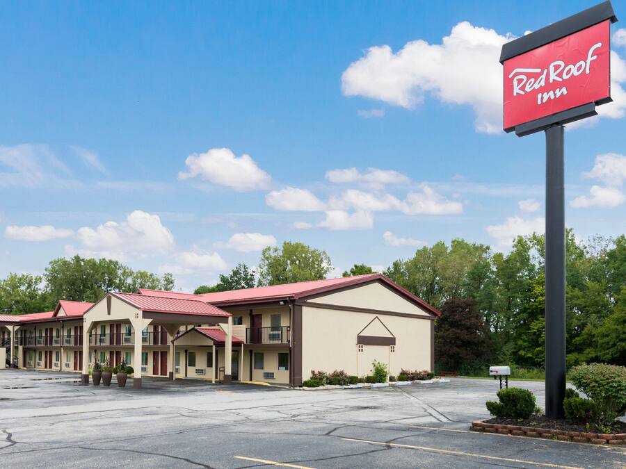 Un Red Roof Inn con estacionamiento y varias construcciones.