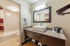 A bathroom with a white sink, a mirror, a towel rack, and a shower curtain.