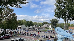 A street parade with spectators and a large inflatable dolphin. - Colonial Motel (Wisconsin Dells)