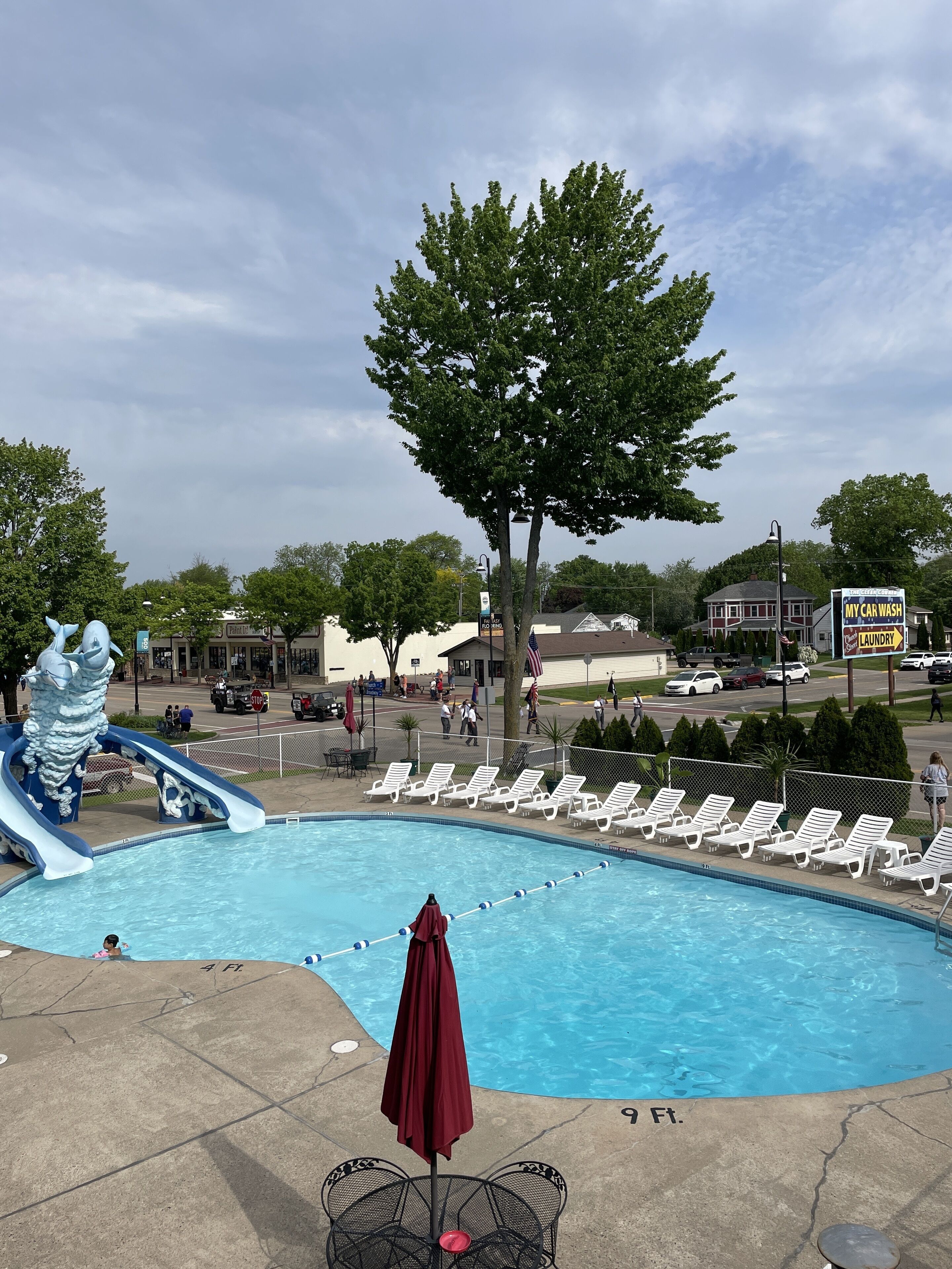 A swimming pool with lounge chairs and a water slide.