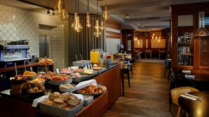 A buffet with various food items and a coffee station. - Reykjavik Konsulat Hotel, Curio Collection by Hilton (Reykjavik)