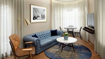 A modern living room with a blue sofa, a round coffee table, and a television.