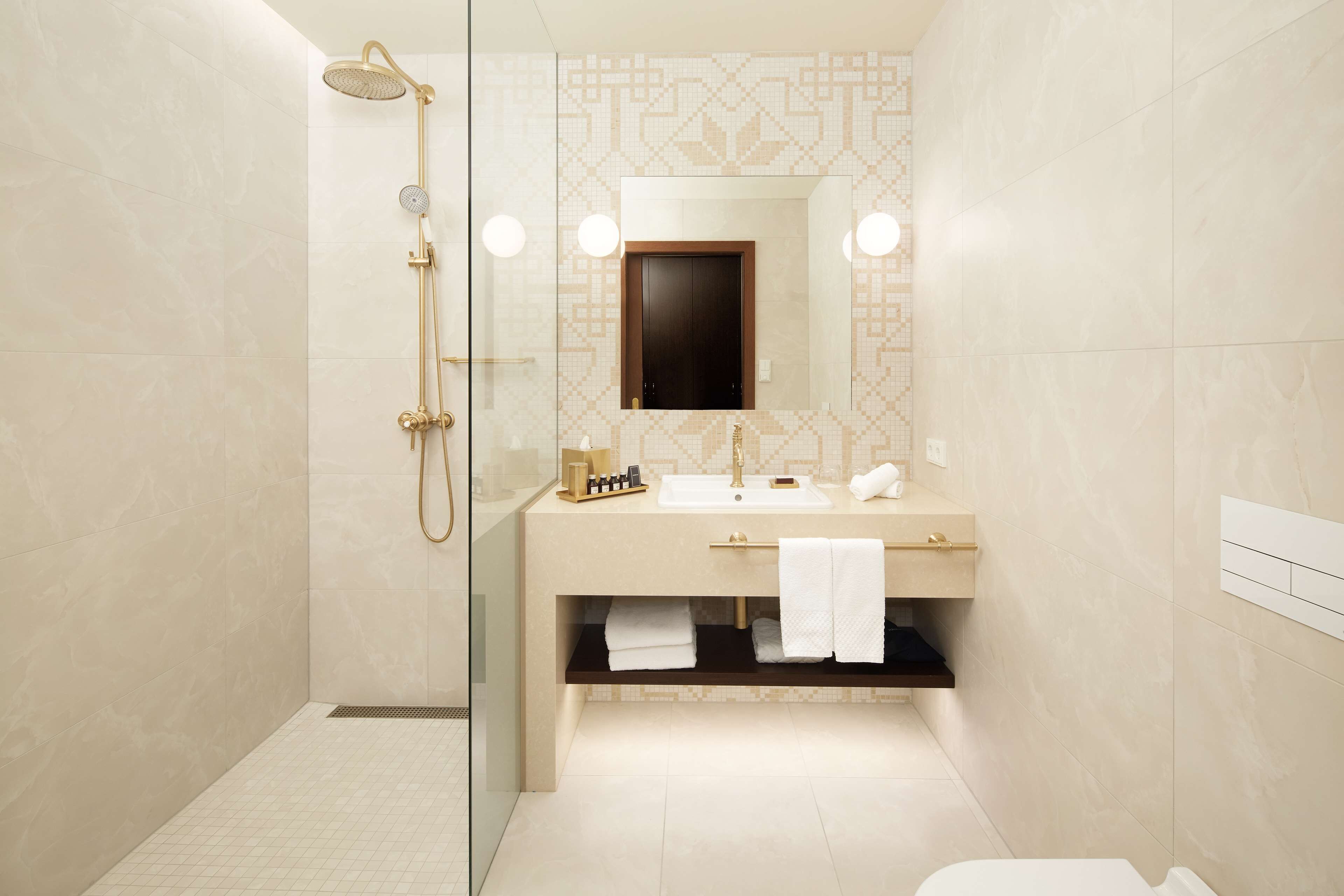 A modern bathroom with a glass-enclosed shower, a vanity with a mirror, and a toilet.