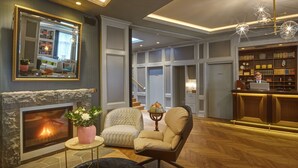A modern living room with a fireplace, comfortable seating, a bookshelf, and a bar area. - Reykjavik Konsulat Hotel, Curio Collection by Hilton (Reykjavik)