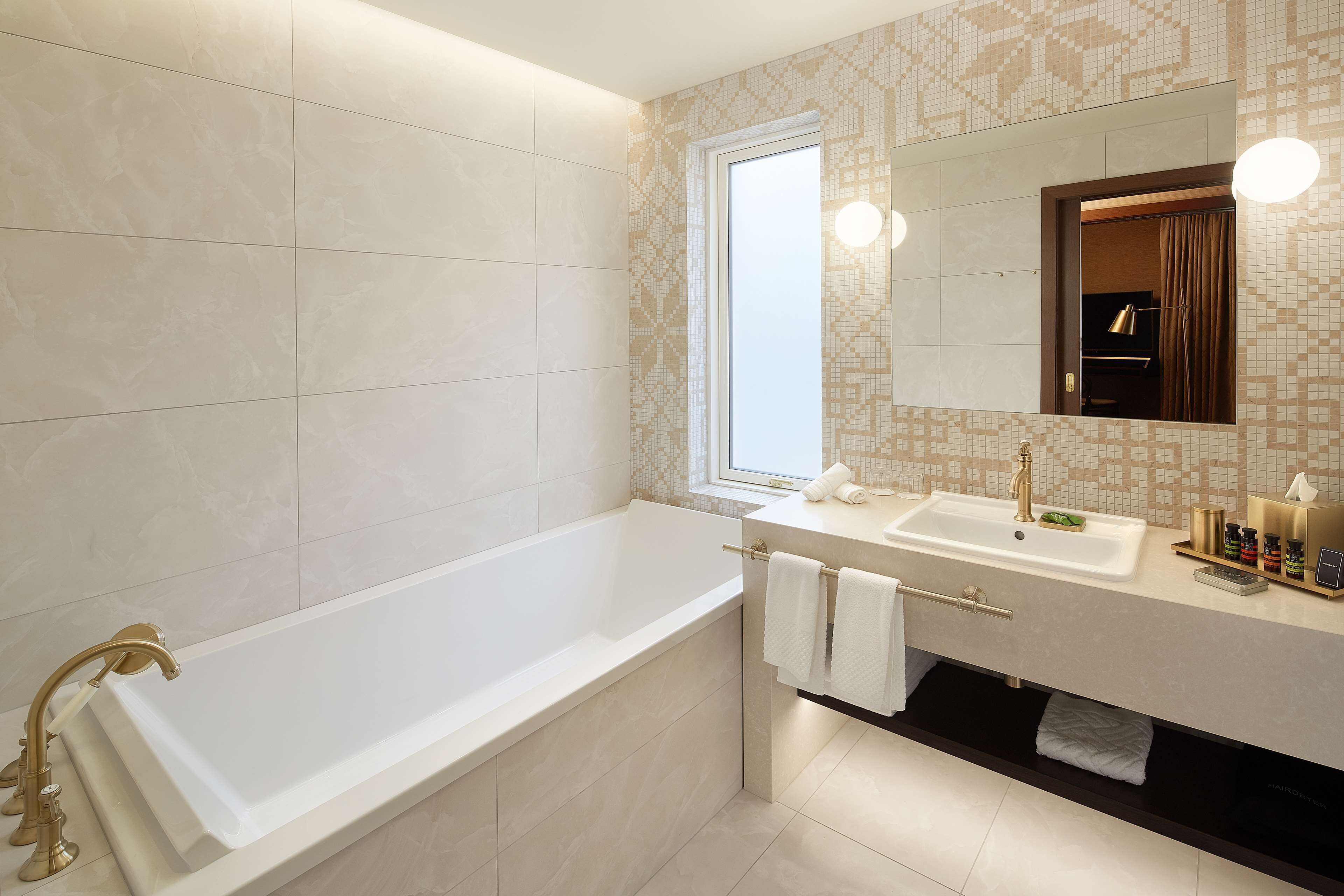 A modern bathroom with a bathtub, a sink, and a mirror.