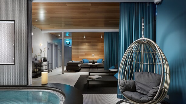 A modern spa room with a hot tub, a hanging chair, and a seating area with a sofa and coffee table. - Reykjavik Konsulat Hotel, Curio Collection by Hilton (Reykjavik)