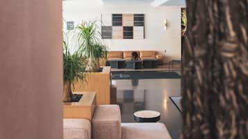 A modern lobby with a seating area, a coffee bar, and a large window.