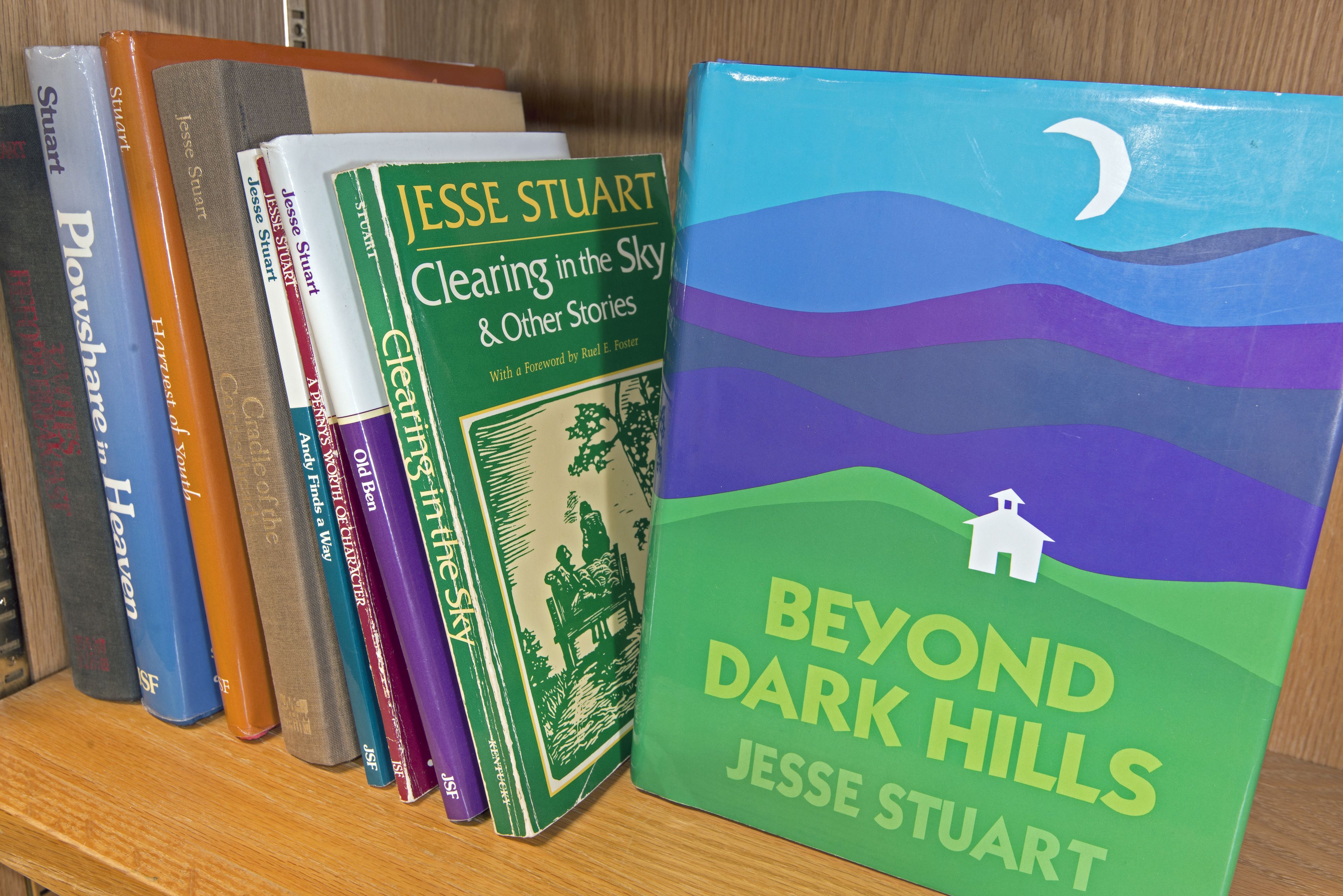 Une bibliothèque remplie de livres, dont « Beyond Dark Hills » de Jesse Stuart.
