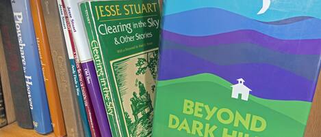 A bookshelf with books, including 'Beyond Dark Hills' by Jesse Stuart.
