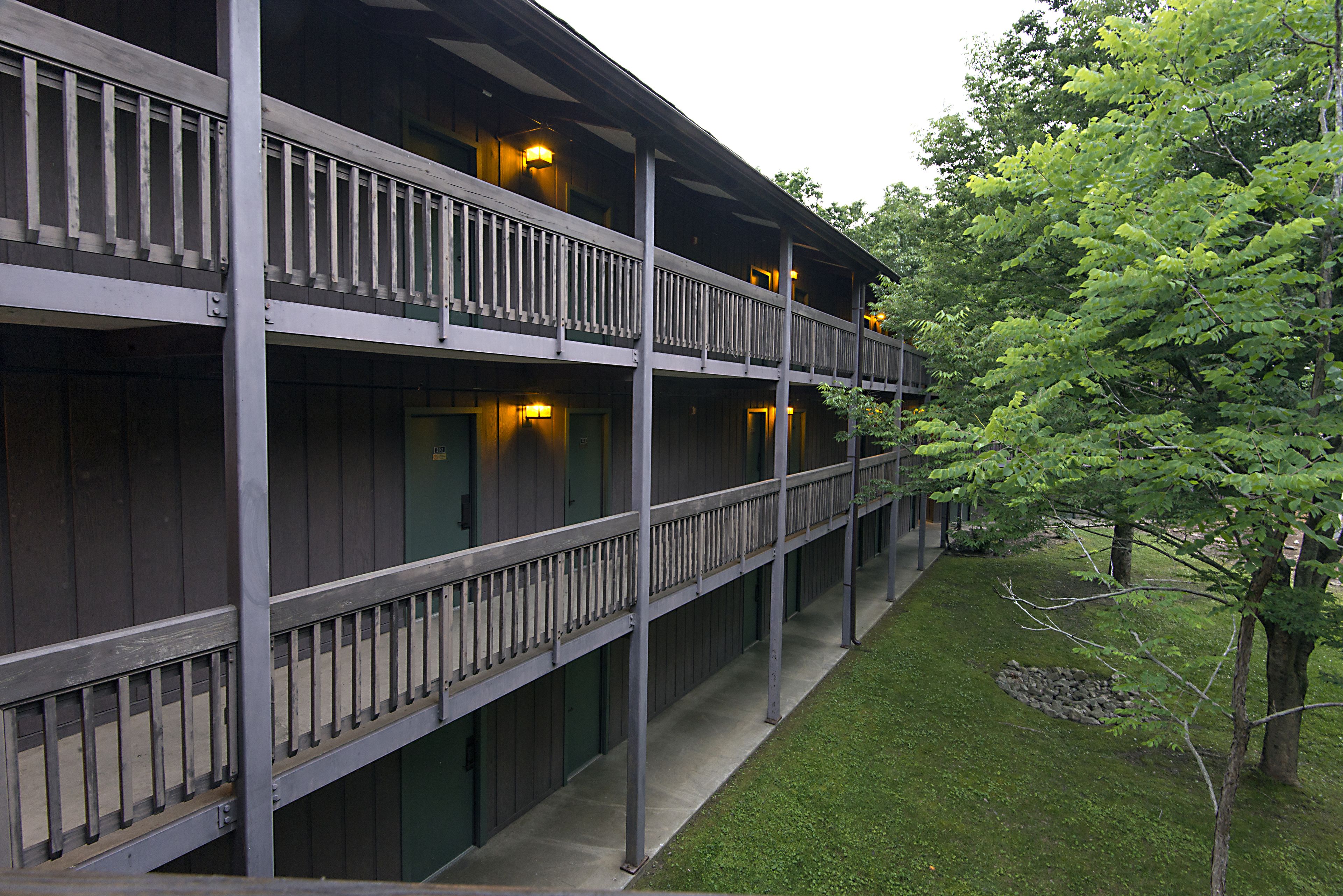 A multi-story building with balconies and a well-maintained lawn.