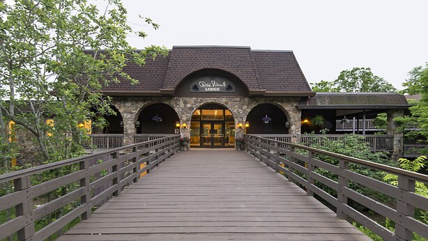 Un bâtiment en pierre avec une enseigne indiquant « Cottage Street Lodge » et un pont en bois menant à ce bâtiment.