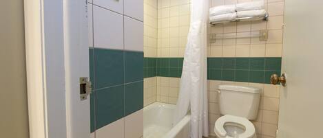 Un baño con bañera, inodoro y cortina de ducha.