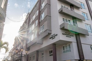 Un edificio de hotel de varios pisos con balcones y un letrero que dice "HOTEL NOVUS PLAZA HODELPA".