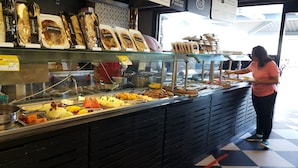 A food display with various items like bread and pastries. - Barrabella Pé na areia (Rio de Janeiro)