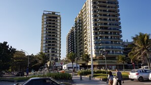 A street view with tall residential buildings, a crosswalk, and pedestrians. - Barrabella Pé na areia (Rio de Janeiro)