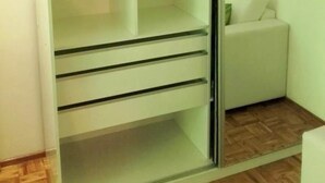A room with a glass-fronted wardrobe, a wooden floor, and a white sofa. - Isla Verde (Rosario)