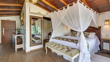 Una camera da letto con un letto a baldacchino, uno specchio, una panca e un soffitto in legno.