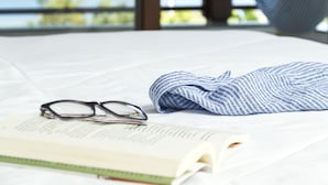 A hammock, a book, and glasses on a bed with a view of mountains and water. - Haute Haus (Florianópolis)