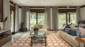 A modern living room with a sofa, coffee table, and a patterned rug. - Haute Haus (Florianópolis)