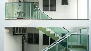 Un edificio residencial moderno de dos pisos, con una escalera de cristal que conecta los niveles.