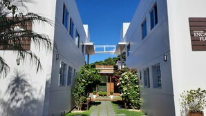 Un edificio moderno con un atrio central, paredes blancas y un cielo azul claro.