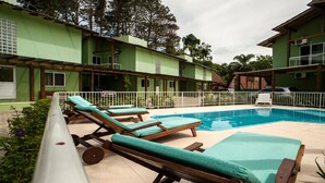 Zona de piscina con sillas de descanso y una piscina.