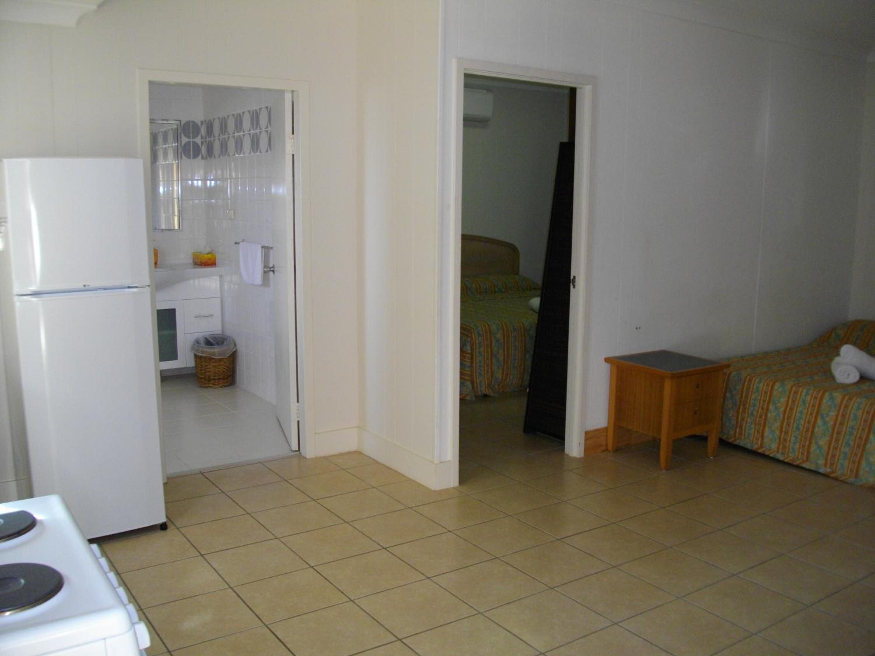 Ein kleines Zimmer mit Küchenzeile, einem Bett und einem kleinen Tisch.