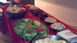 A buffet table with various dishes including salads, pasta, and other foods. - Kurrmine Beach Motel (Kurrimine Beach)
