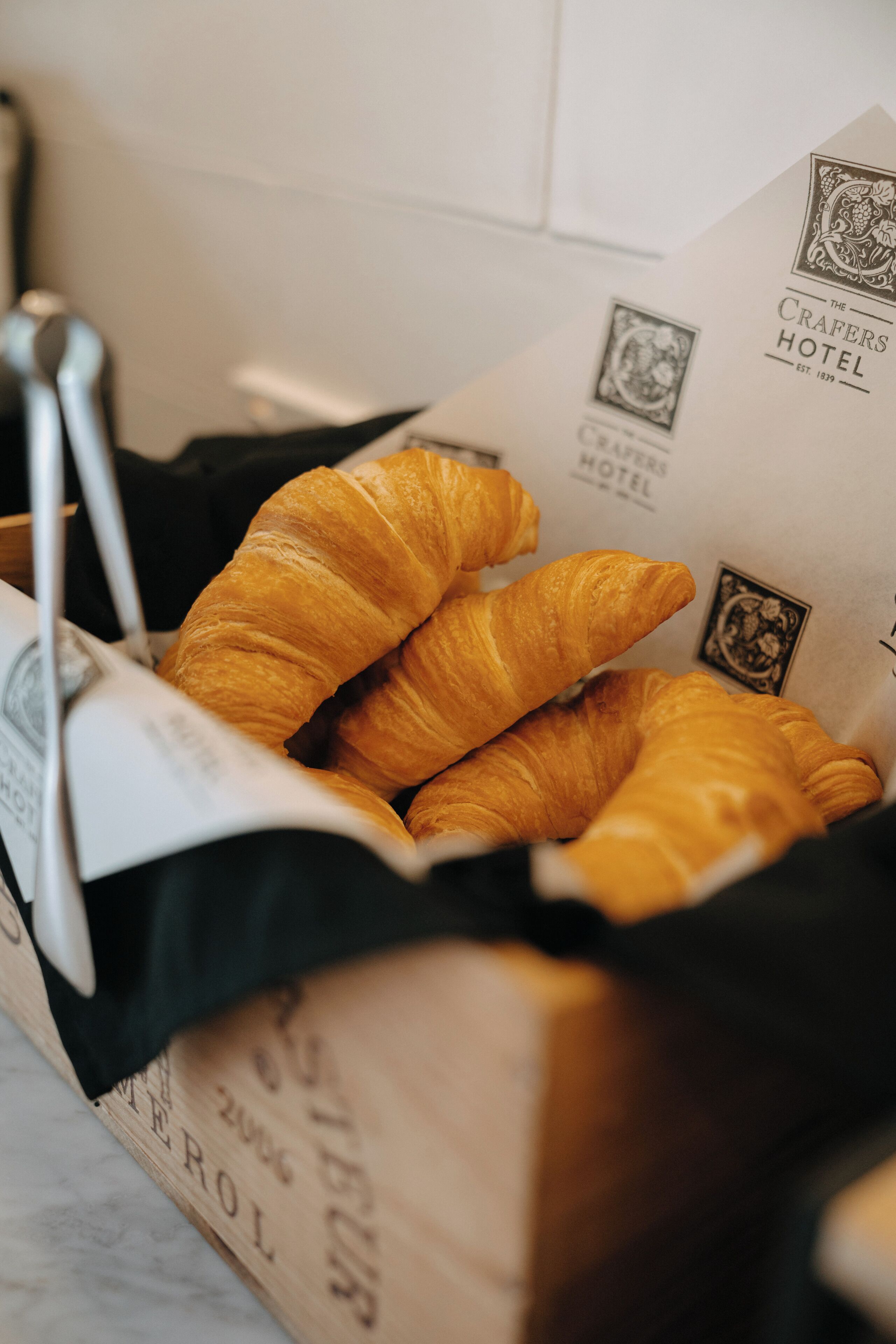 A box containing croissants with a hotel logo and name visible.