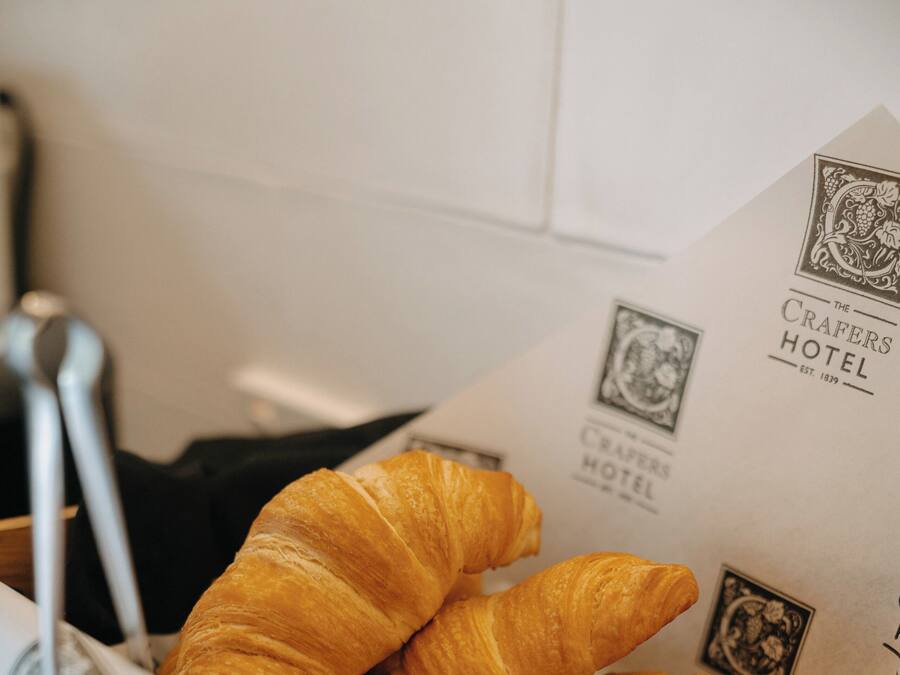 A box containing croissants with a hotel logo and name visible.