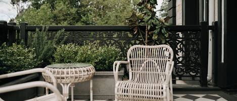 A checkered outdoor patio with wicker furniture and a potted plant.