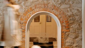 Un muro de piedra con un arco de ladrillo que conduce a una habitación.