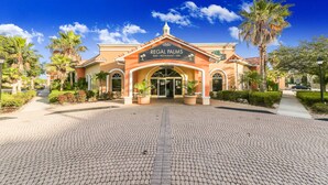L’extérieur de l’hôtel Regal Palms se caractérise par une façade de style méditerranéen, une entrée principale agrémentée d’une enseigne et des palmiers qui l’entourent.
